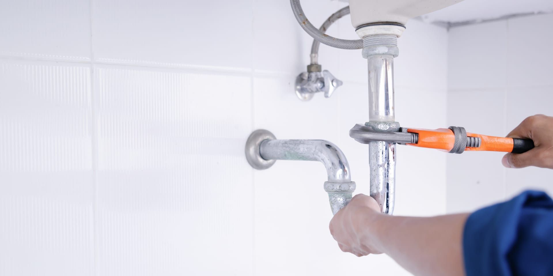 BR McGinty plumber repairing a drain pipe under a sink in Little Rock